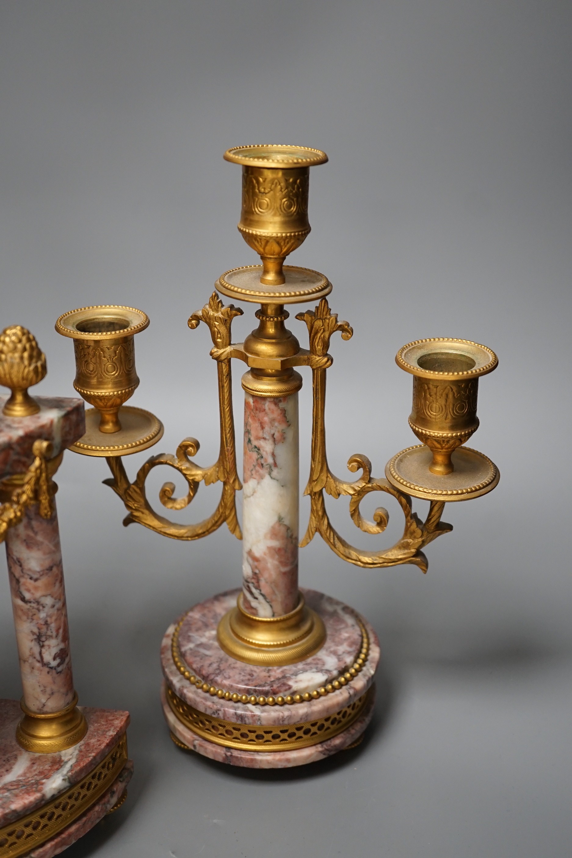 A French ormulu and rouge marble clock garniture, c.1900, with decorative enamel dial, 40cms high.